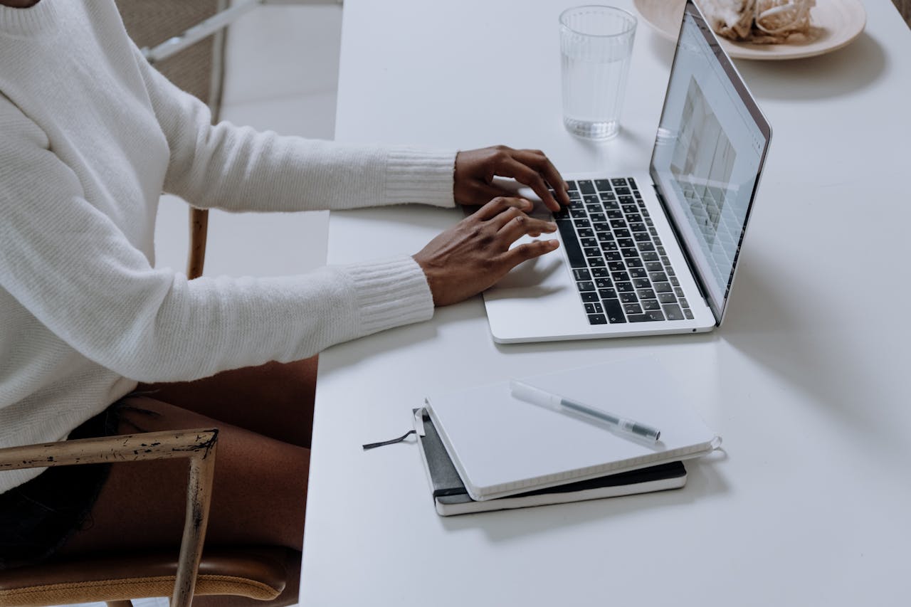 why-choose-us A person typing on a laptop in a minimalistic home office setting, capturing modern work culture.